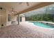 An in-ground pool sits on a brick patio enclosed by a screened cage overlooking a wooded backyard at 343 Leslie Ln, Lake Mary, FL 32746