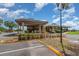 View of the community clubhouse showcasing covered entrance, landscaping, and parking area at 3887 Atrium Dr # 3, Orlando, FL 32822