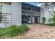 Multi-story exterior with blue siding, screened patios, gravel landscaping, and lush greenery at 3887 Atrium Dr # 3, Orlando, FL 32822