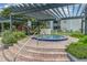 Community hot tub with pergola, surrounded by brick pavers and lush landscaping, offering a relaxing retreat at 3887 Atrium Dr # 3, Orlando, FL 32822