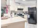 Galley kitchen with white cabinets, black appliances, and laminate counters provide efficiency and style at 3887 Atrium Dr # 3, Orlando, FL 32822