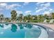 Community pool area with inviting clear blue water, surrounding palm trees, and ample lounging space at 3887 Atrium Dr # 3, Orlando, FL 32822