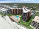 Aerial view showcasing condo complex with a heart shaped pool, boardwalk, and beach access at 4141 S Atlantic Ave # 707, New Smyrna Beach, FL 32169