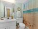 Bathroom with decorative wheel, seashell decor, beach-themed shower curtain, and white vanity at 4141 S Atlantic Ave # 707, New Smyrna Beach, FL 32169