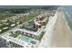 Aerial view of a Florida community situated right on the sandy beach with multiple condos and pools at 4141 S Atlantic Ave # 707, New Smyrna Beach, FL 32169