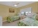 Bedroom featuring twin beds with tropical bedding, art, and a ceiling fan at 4141 S Atlantic Ave # 707, New Smyrna Beach, FL 32169