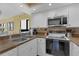 Well-lit kitchen with stainless steel microwave and range, white cabinets, and granite countertops at 4141 S Atlantic Ave # 707, New Smyrna Beach, FL 32169