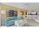 Living room with bright natural light, comfortable blue sofa, open to the kitchen at 4141 S Atlantic Ave # 707, New Smyrna Beach, FL 32169