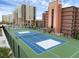 Bright blue and green community tennis courts sit beside tall tan condos on a partly cloudy day at 4141 S Atlantic Ave # 707, New Smyrna Beach, FL 32169