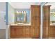 Bathroom with wooden cabinets, granite countertops, decorative mirror, and a large shower at 428 N Pine Meadow Dr, Debary, FL 32713