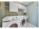Functional laundry room with modern washer and dryer, sink, and ample storage at 428 N Pine Meadow Dr, Debary, FL 32713