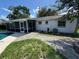 View of the backyard with a screened-in patio and mature trees at 4534 Lemans Dr, Orlando, FL 32808