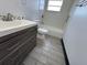 This bathroom features white tile, toilet and gray vanity with white sink at 4534 Lemans Dr, Orlando, FL 32808
