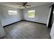 This bedroom features gray wood-look floors, two windows and a ceiling fan at 4534 Lemans Dr, Orlando, FL 32808