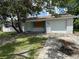 Charming single-story home with white brick, an attached garage and is adorned with mature trees and ample front yard space at 4534 Lemans Dr, Orlando, FL 32808