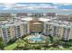 An aerial view shows the condo building with a pool and covered parking at 4650 Links Village Dr # B103, Ponce Inlet, FL 32127