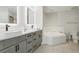 Modern bathroom with double sink vanity, a soaking tub, and white tiled floors at 4650 Links Village Dr # B103, Ponce Inlet, FL 32127
