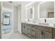 Modern bathroom featuring double sinks, a light gray vanity, and ample storage, providing a luxurious and functional space at 4650 Links Village Dr # B103, Ponce Inlet, FL 32127