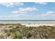 Beautiful beach view with a wooden walk way, blue sky, and some people relaxing on the sand at 4650 Links Village Dr # B103, Ponce Inlet, FL 32127