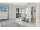 Bedroom with wood floors, a chair with ottoman, and sliding glass doors to the patio at 4650 Links Village Dr # B103, Ponce Inlet, FL 32127