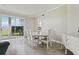 Bright dining area with wood floors, a white table set, and sliding glass doors to the outside at 4650 Links Village Dr # B103, Ponce Inlet, FL 32127