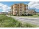 Beautiful yellow condominium building featuring multiple balconies with manicured landscaping and blue skies at 4650 Links Village Dr # B103, Ponce Inlet, FL 32127