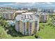 An aerial view shows the exterior of the condo building and green spaces at 4650 Links Village Dr # B103, Ponce Inlet, FL 32127