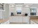 Bright kitchen featuring sleek white cabinets, granite countertops, and modern appliances at 4650 Links Village Dr # B103, Ponce Inlet, FL 32127
