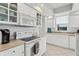 Well-lit kitchen with white cabinetry, a sleek microwave, and stainless-steel appliances at 4650 Links Village Dr # B103, Ponce Inlet, FL 32127