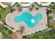 Aerial view of a large community pool with lounge chairs and palm trees at 4650 Links Village Dr # B103, Ponce Inlet, FL 32127