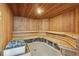A view of the sauna room, featuring wood paneling and tiered benches at 4650 Links Village Dr # B103, Ponce Inlet, FL 32127