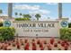 Landmark sign for Harbour Village Golf & Yacht Club with colorful floral landscaping at 4650 Links Village Dr # B103, Ponce Inlet, FL 32127