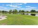 Expansive backyard with a tranquil pond view, lush lawn, and a paved patio, perfect for enjoying nature at 5305 Ingleside, Leesburg, FL 34748