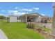 Charming home featuring a covered carport, lush lawn and garden with a tranquil pond view in the background at 5305 Ingleside, Leesburg, FL 34748