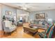 Bright living room with hardwood floors, cozy seating, and an open layout leading to the dining and kitchen areas at 5305 Ingleside, Leesburg, FL 34748