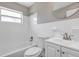 Bathroom featuring a white tiled shower, toilet, vanity, and a round mirror at 603 Carver Dr, Lake Wales, FL 33853