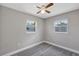 Bedroom featuring neutral walls, gray floors, and two windows at 603 Carver Dr, Lake Wales, FL 33853