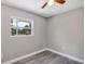 The bedroom features neutral walls, wood-look flooring, and a bright window with green outdoor views at 603 Carver Dr, Lake Wales, FL 33853