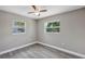 Bedroom featuring neutral walls, gray floors, and two windows at 603 Carver Dr, Lake Wales, FL 33853