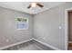 Cozy bedroom featuring modern gray floors, neutral walls, and a ceiling fan at 603 Carver Dr, Lake Wales, FL 33853