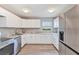 The kitchen features stainless steel appliances, white cabinets, stone countertops, and wood-look flooring at 603 Carver Dr, Lake Wales, FL 33853