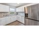 The kitchen offers sleek stainless steel appliances, white cabinets, and stone countertops at 603 Carver Dr, Lake Wales, FL 33853