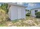 Outdoor view of a white detached shed with a door and a small window at 603 Carver Dr, Lake Wales, FL 33853