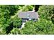 Nestled among lush trees, the house boasts a serene, private setting with a charming exterior and natural landscape at 625 Woodlawn Cemetery Rd, Gotha, FL 34734