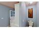 Powder room features blue walls, a white toilet, and decorative artwork at 625 Woodlawn Cemetery Rd, Gotha, FL 34734