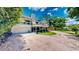 View of home showcasing multi-level deck, lush landscaping, and brick driveway for a beautiful curb appeal at 625 Woodlawn Cemetery Rd, Gotha, FL 34734