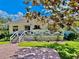 Inviting home with a spacious porch, white railing, and a well-manicured lawn and brick driveway at 625 Woodlawn Cemetery Rd, Gotha, FL 34734