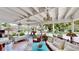 Bright sun room with comfortable seating, decorative chandeliers, and a picturesque view of the landscaped backyard at 625 Woodlawn Cemetery Rd, Gotha, FL 34734