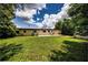 Spacious backyard with a patio area, lush lawn, and mature trees for outdoor enjoyment at 6310 Lake Underhill Rd, Orlando, FL 32807