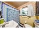 Bathroom with floral wallpaper, and blue printed curtain at 6310 Lake Underhill Rd, Orlando, FL 32807
